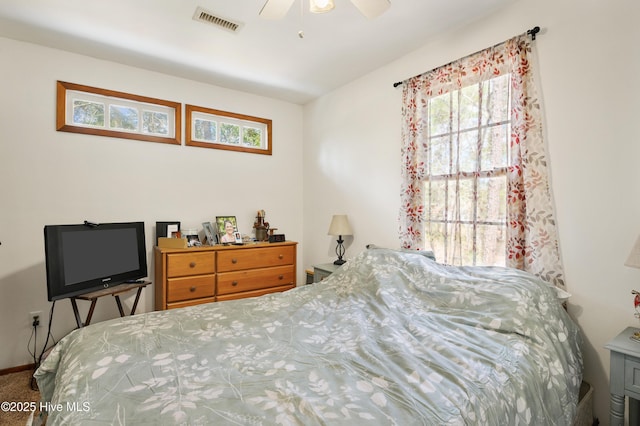 carpeted bedroom with visible vents, baseboards, and ceiling fan