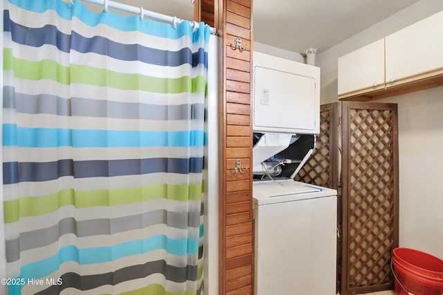 interior space with curtained shower and stacked washer and clothes dryer