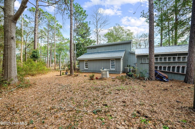 back of property with central air condition unit and metal roof