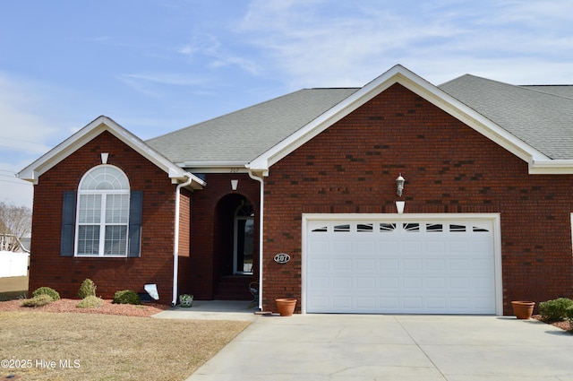 view of front of home with concrete driveway, a garage, brick siding, and a shingled roof