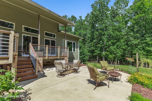 view of patio featuring a fire pit, outdoor dining area, and stairway