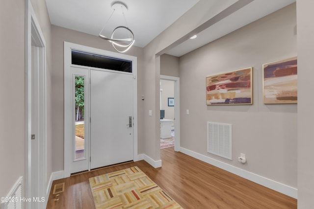 entrance foyer featuring visible vents, baseboards, and wood finished floors