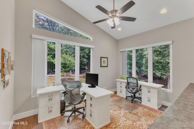 office space featuring vaulted ceiling, baseboards, plenty of natural light, and light wood finished floors