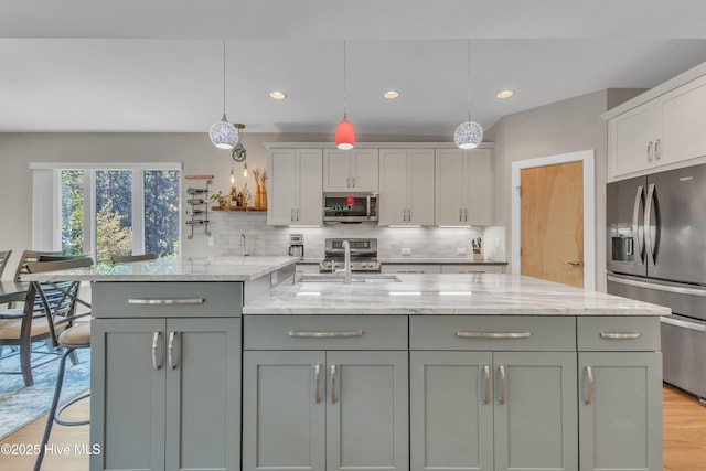 kitchen with stainless steel appliances, hanging light fixtures, decorative backsplash, and a sink