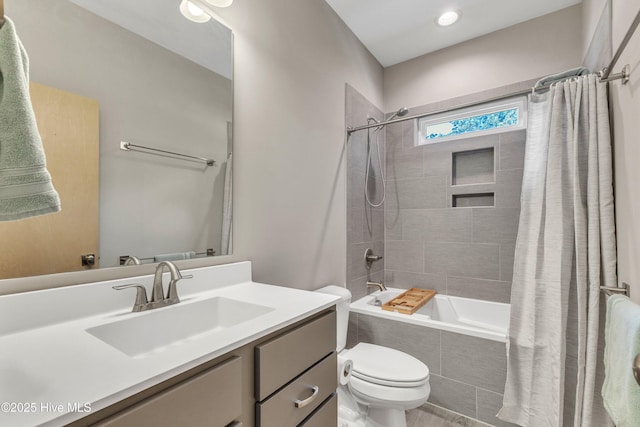 full bathroom featuring toilet, tiled shower / bath combo, and vanity