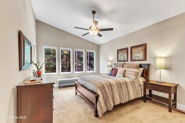 bedroom with baseboards, vaulted ceiling, a ceiling fan, and light colored carpet