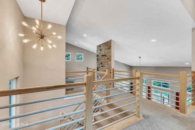 corridor with a chandelier, lofted ceiling, recessed lighting, carpet flooring, and an upstairs landing