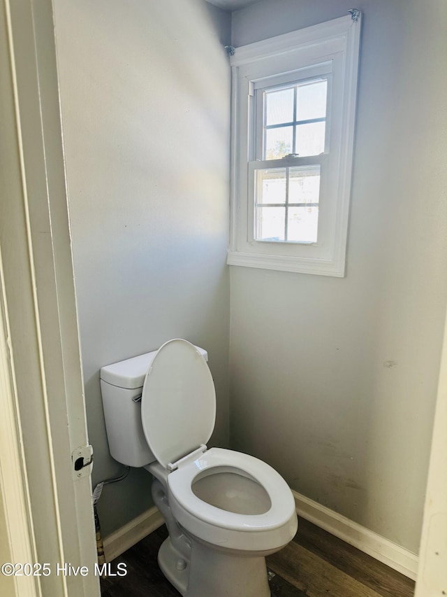 bathroom with toilet, baseboards, and wood finished floors