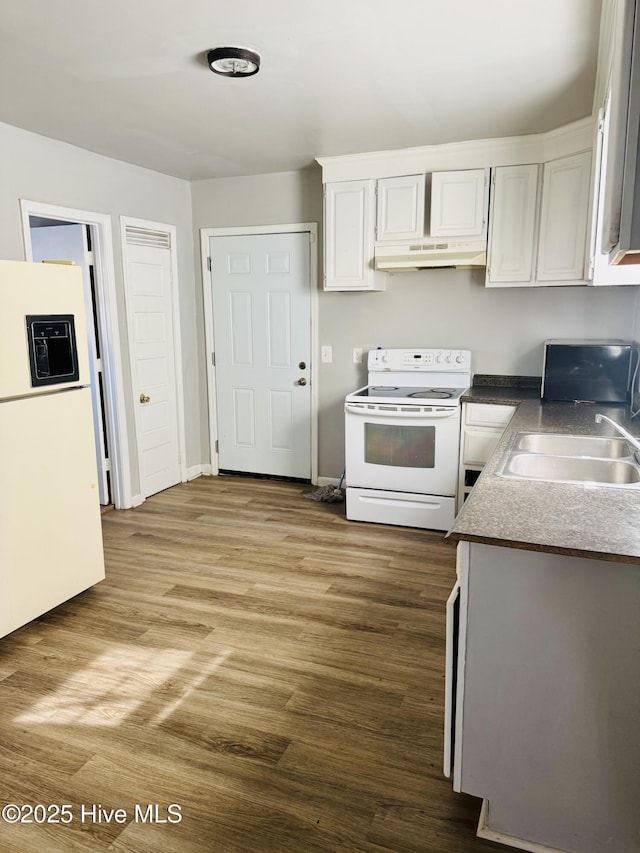 kitchen featuring under cabinet range hood, white appliances, wood finished floors, a sink, and white cabinetry