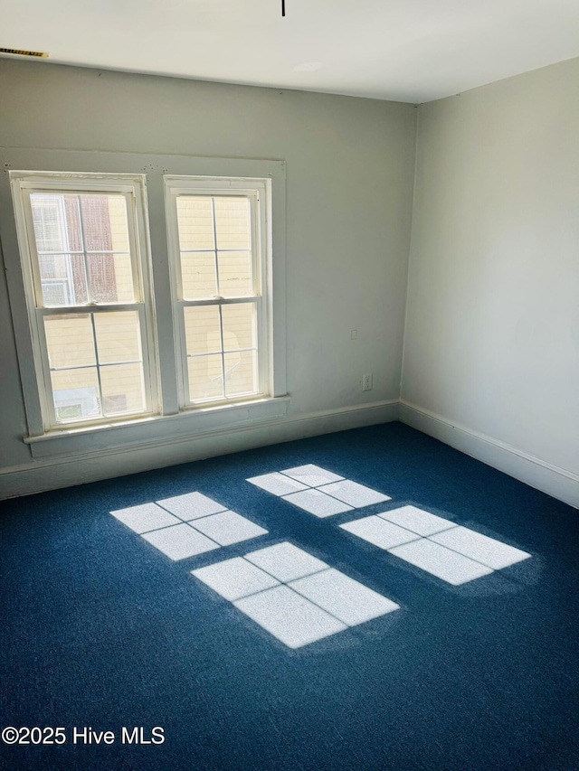 carpeted empty room with baseboards and visible vents