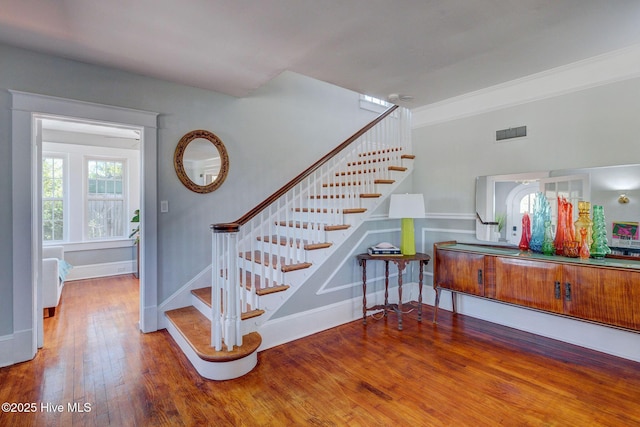 stairs featuring visible vents, baseboards, and hardwood / wood-style flooring