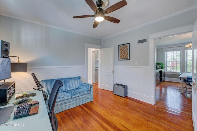 office space with ornamental molding, wood finished floors, visible vents, and wainscoting