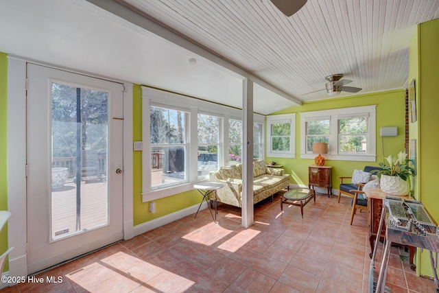 sunroom / solarium featuring a healthy amount of sunlight, lofted ceiling, and a ceiling fan