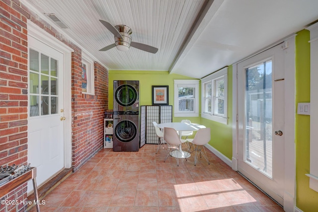 unfurnished sunroom featuring vaulted ceiling with beams, visible vents, and stacked washer / drying machine