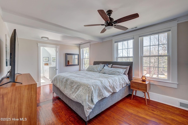 bedroom featuring visible vents, baseboards, ensuite bath, and hardwood / wood-style floors