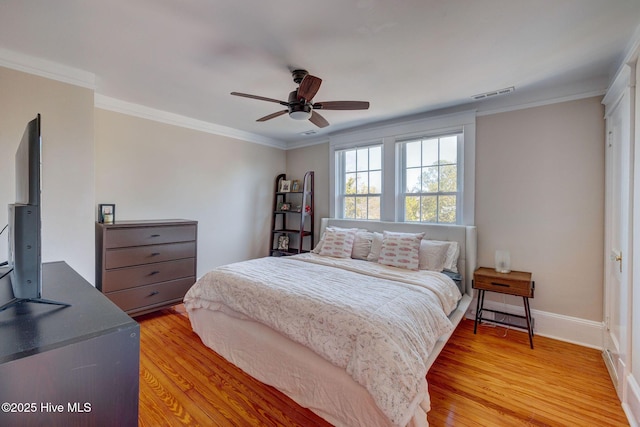 bedroom with visible vents, crown molding, light wood-type flooring, and baseboards