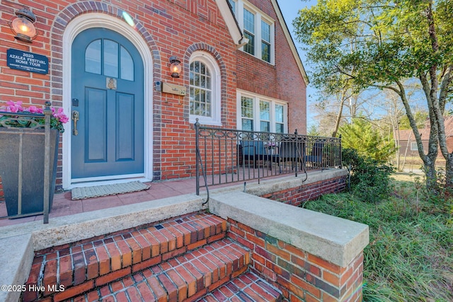 entrance to property featuring brick siding