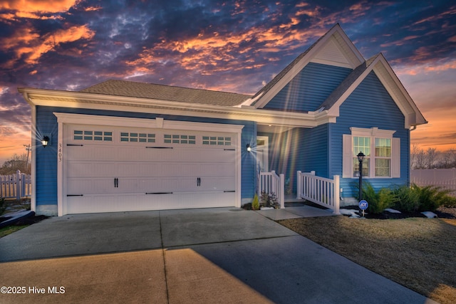 view of front of property with a garage, driveway, and fence