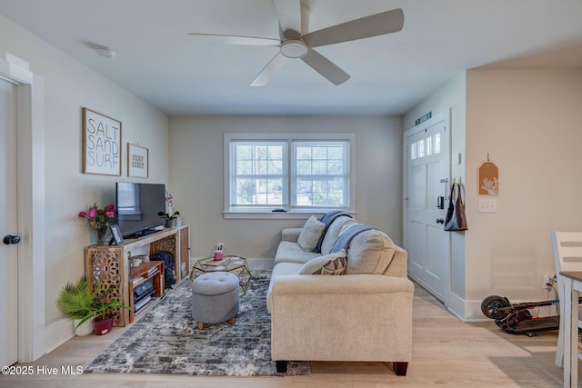 living area with ceiling fan and light wood finished floors