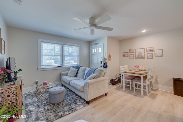 living room featuring recessed lighting, baseboards, ceiling fan, and light wood finished floors