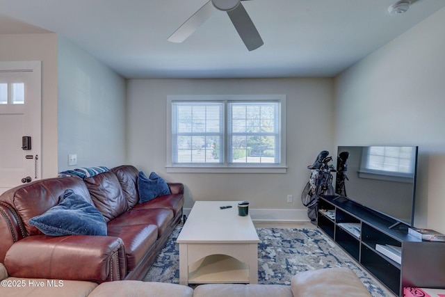 living room with ceiling fan and baseboards