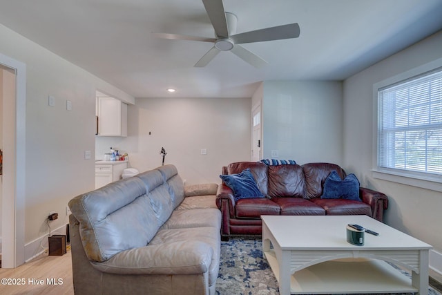 living area with ceiling fan, light wood-type flooring, and baseboards