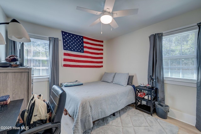 bedroom featuring wood finished floors, a ceiling fan, and baseboards