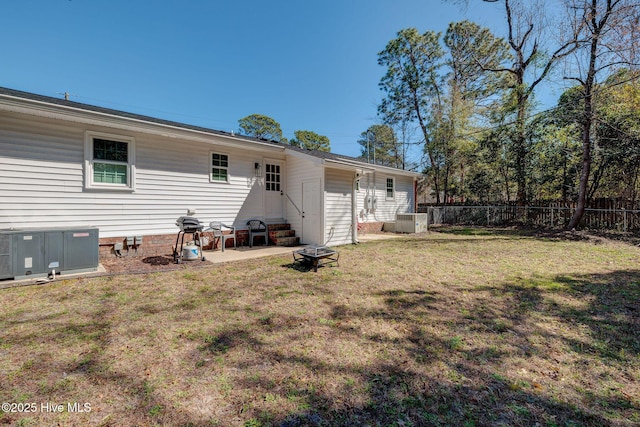 back of property with entry steps, a yard, fence, and central air condition unit