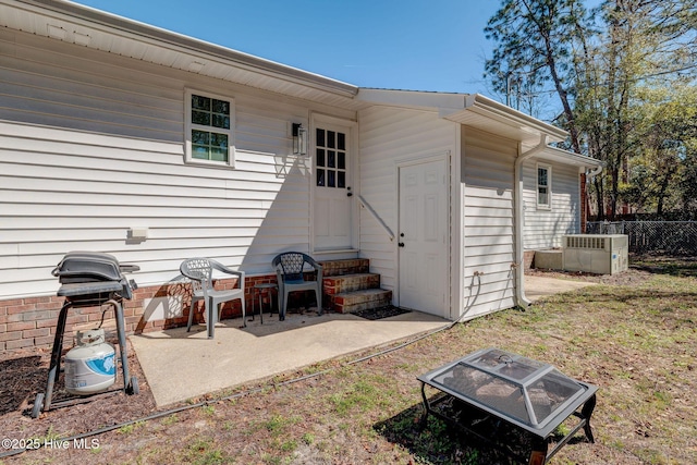 back of property with entry steps, central AC unit, and fence