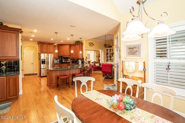 dining area featuring lofted ceiling, recessed lighting, and light wood-style floors