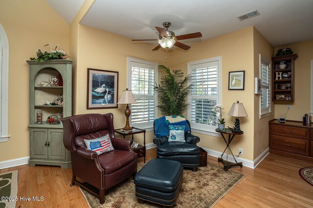 sitting room featuring a ceiling fan, baseboards, visible vents, and wood finished floors