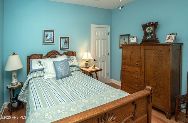 bedroom featuring wood finished floors and baseboards