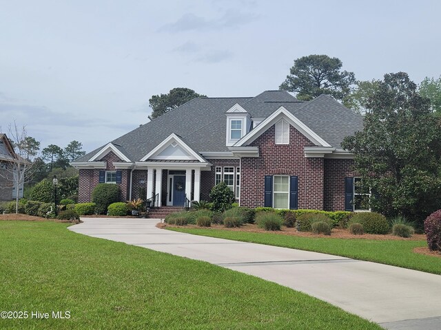 view of front of property with driveway, a front lawn, an attached garage, and brick siding