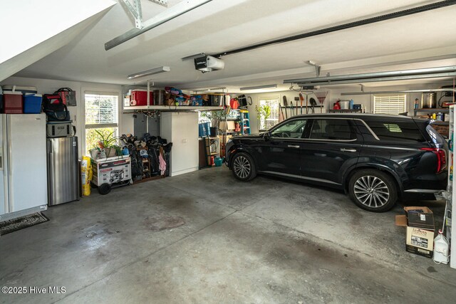 garage featuring a garage door opener and white refrigerator with ice dispenser