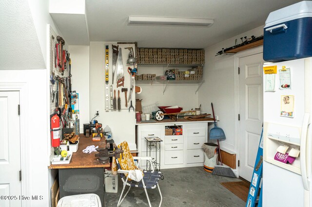 interior space featuring white fridge with ice dispenser and concrete flooring