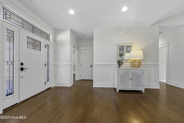 entryway with recessed lighting, wood-type flooring, wainscoting, and a decorative wall