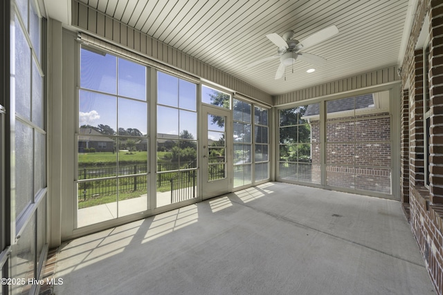 unfurnished sunroom with ceiling fan