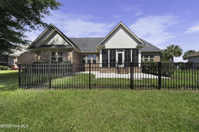 view of front facade with a front yard, brick siding, and fence private yard