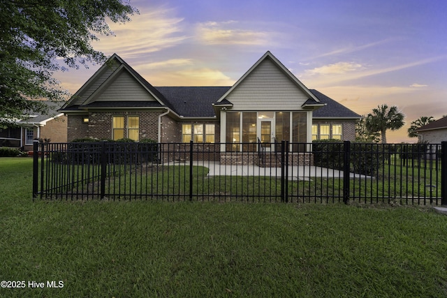 view of front of house featuring a patio area, brick siding, and a front lawn