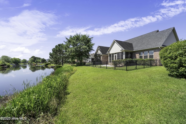 view of yard featuring a water view and fence