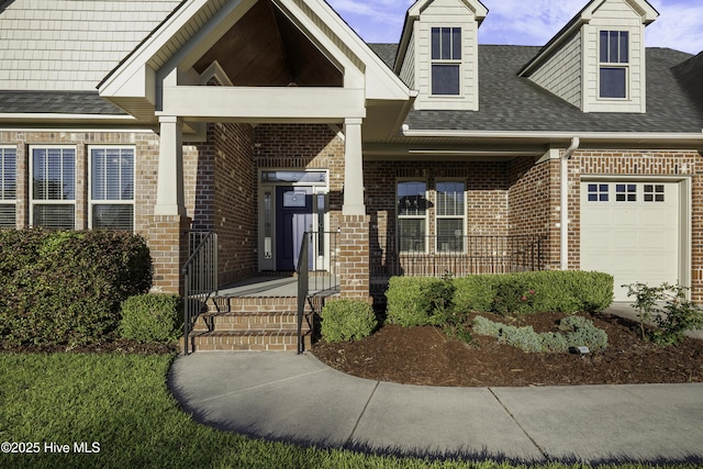 view of front of house with a garage, brick siding, and roof with shingles