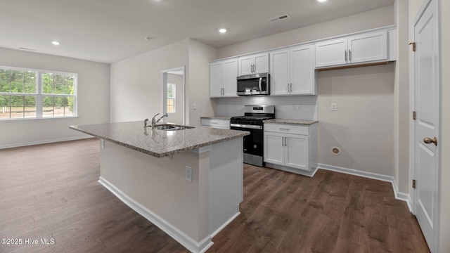 kitchen featuring tasteful backsplash, visible vents, appliances with stainless steel finishes, white cabinetry, and a sink