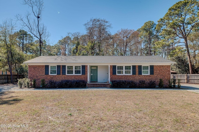 single story home with a front yard, brick siding, and fence