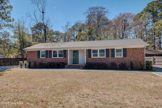 ranch-style house with a front yard, fence, and brick siding