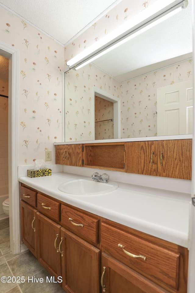 204 Columbia Dr, Jacksonville, NC 28546 - bathroom featuring toilet, vanity, a textured ceiling, tile patterned flooring, and wallpapered walls