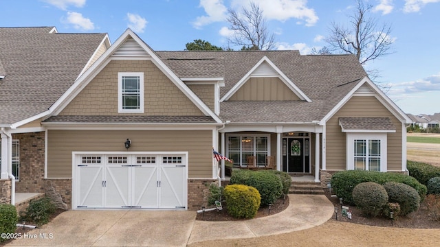 craftsman-style home featuring a garage, concrete driveway, brick siding, and a shingled roof