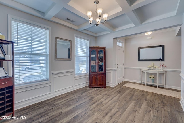 interior space featuring wood finished floors, visible vents, coffered ceiling, beam ceiling, and a chandelier