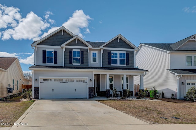 craftsman-style home featuring covered porch, concrete driveway, and an attached garage