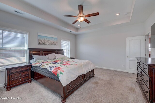 bedroom featuring baseboards, visible vents, a tray ceiling, recessed lighting, and light carpet