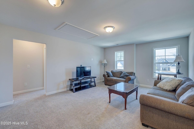 living area with light carpet, attic access, and baseboards